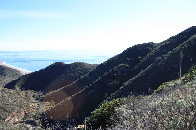 A coastal trail winding through the hills above the ocean.